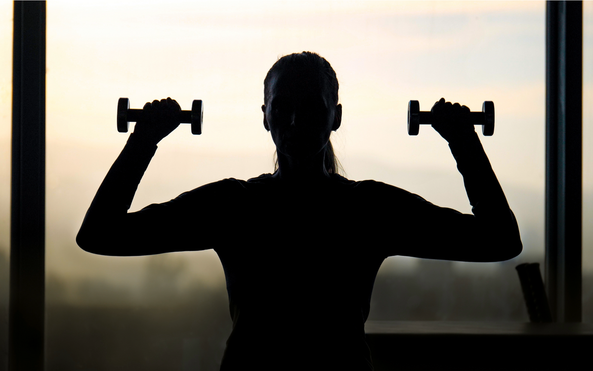 Dieses Bild zeigt eine Frau mittleren Alters mit Hanteln beim Muskeltraining.